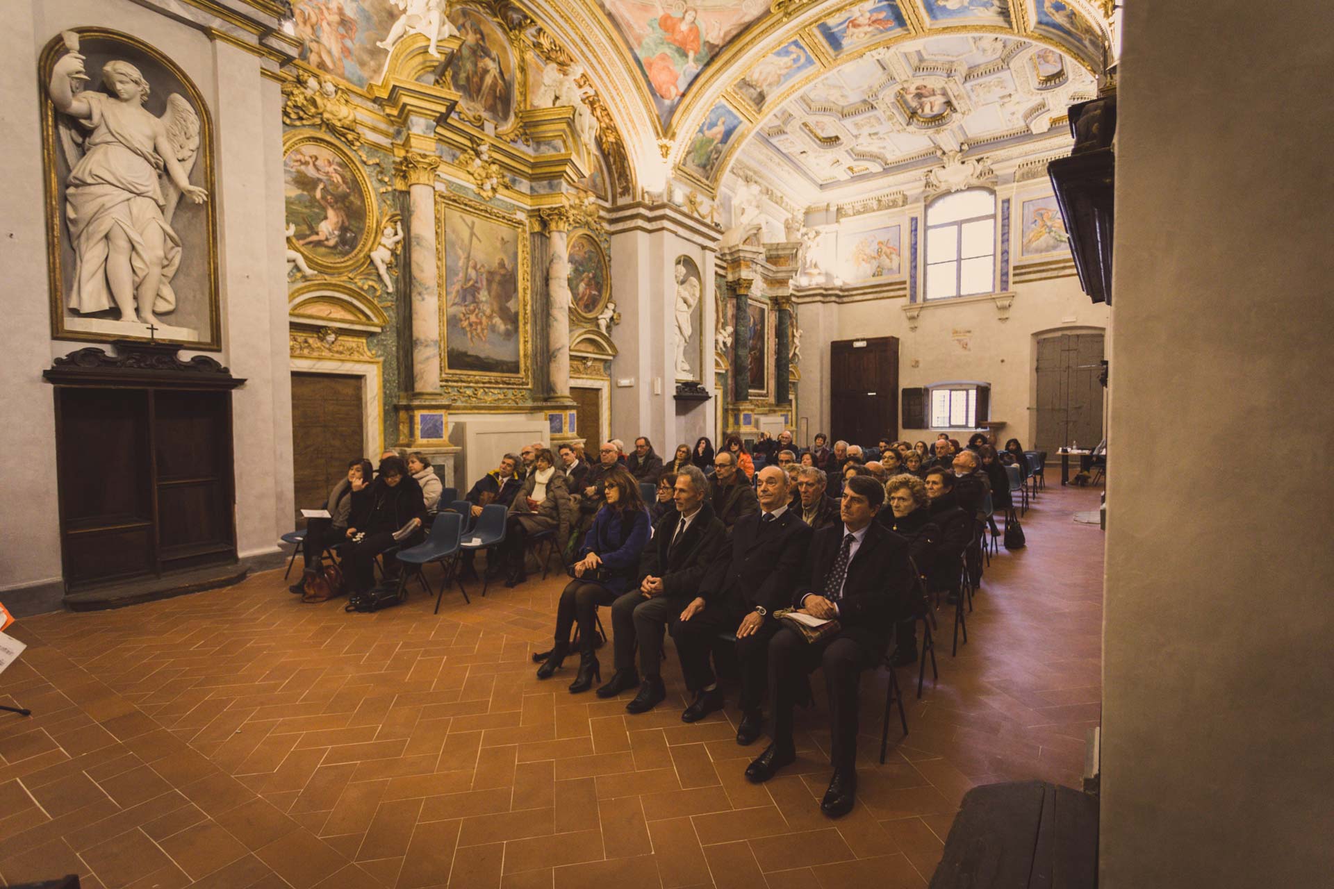 Foto di persone che partecipano a una convention in una sala affrescata