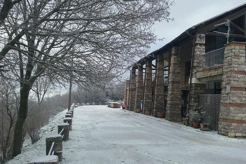 Foto di strada innevata vicino a un edificio in mattoni