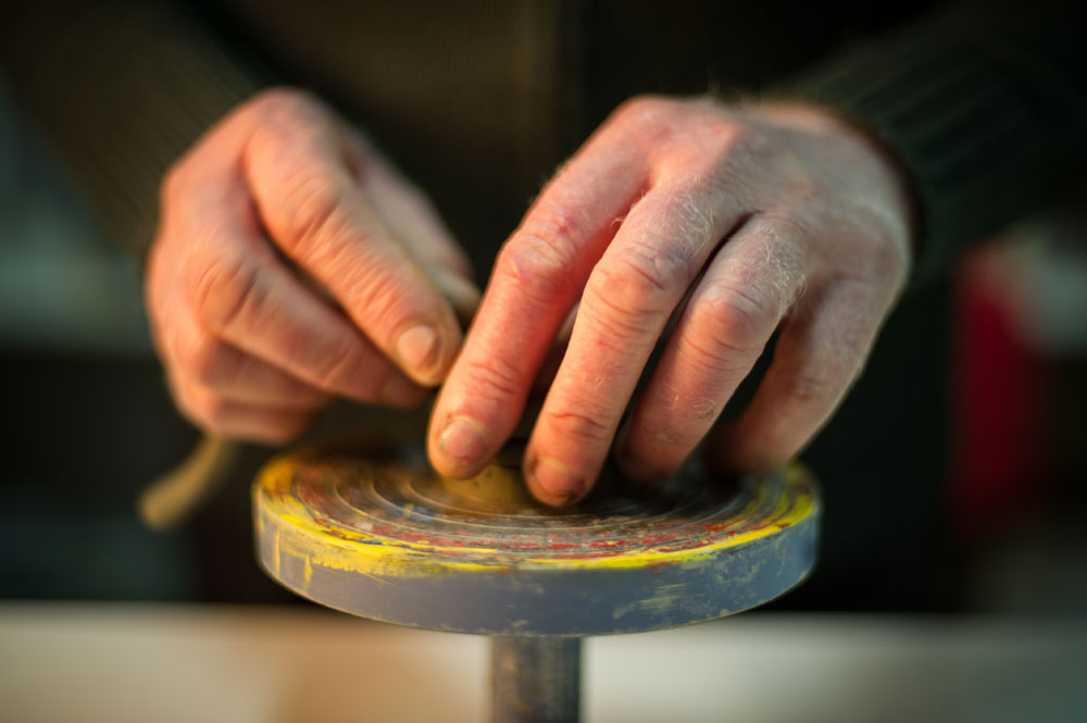 Foto di mani che lavorano l'argilla al tornio