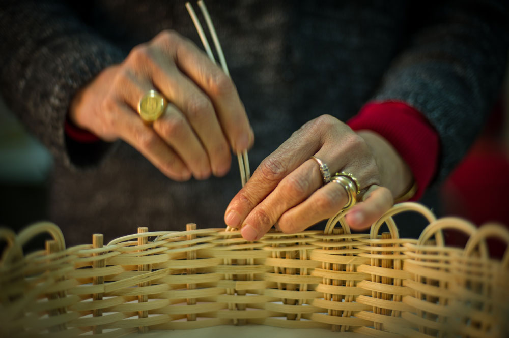 Foto di mani che intrecciano una cesta